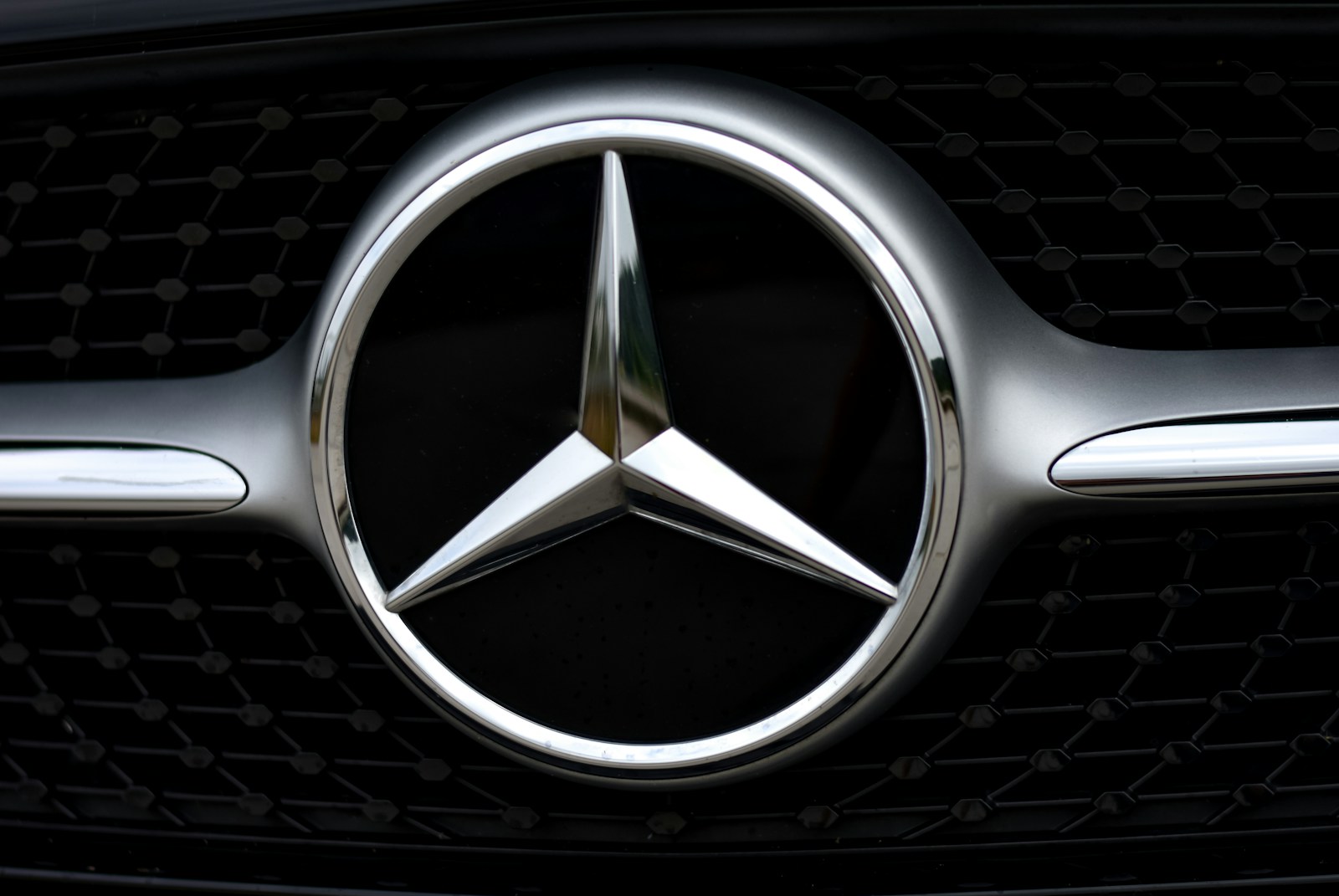 silver mercedes benz emblem on black car