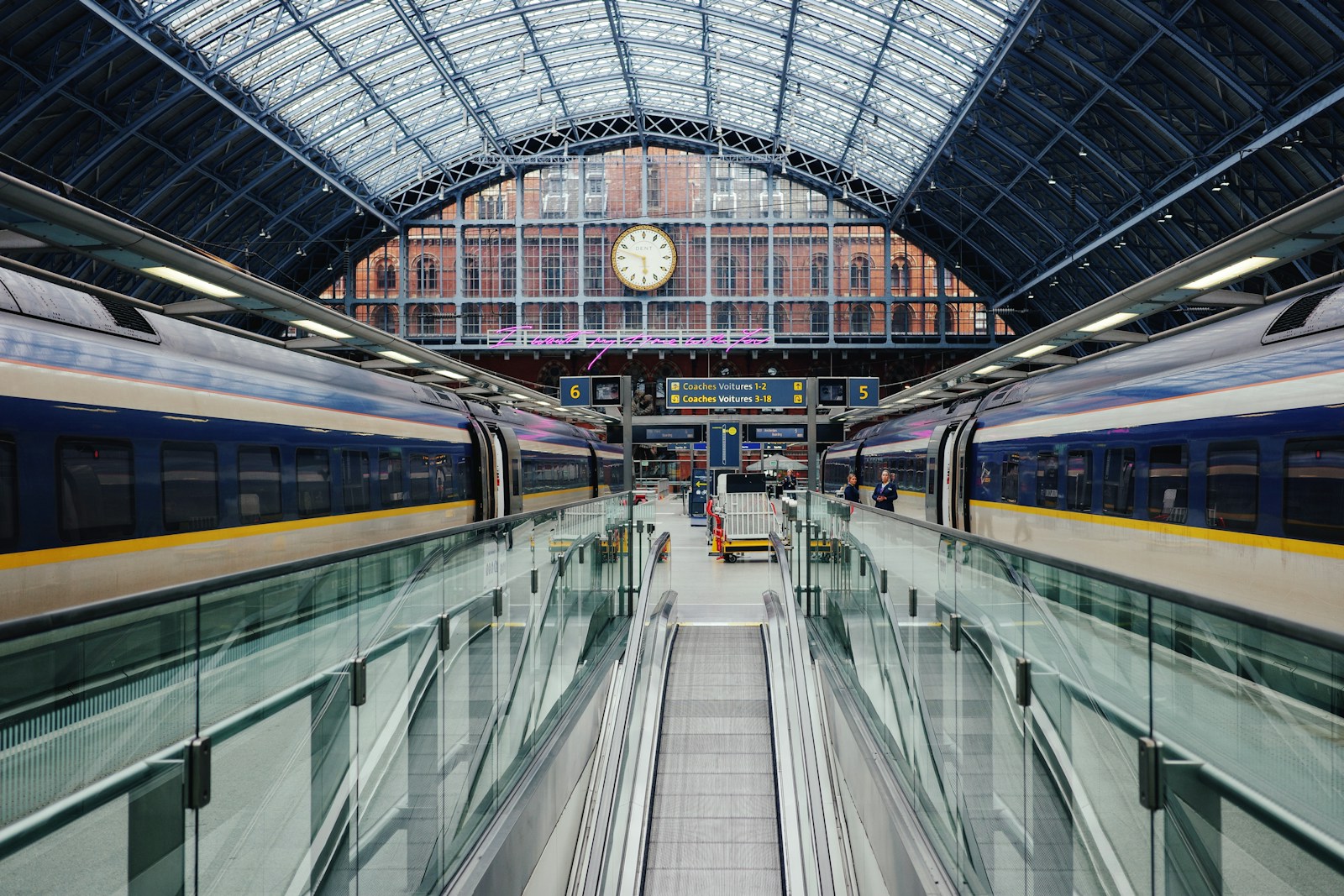 a train traveling through a train station next to a clock