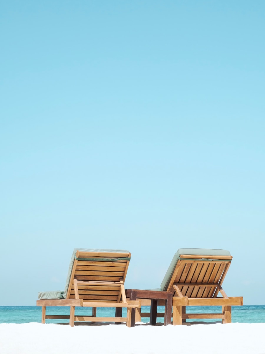 two brown wooden outdoor chaise loungers on beach