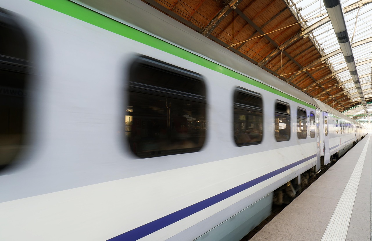 Reizigers wachten op een druk treinstation met een vertraagd vertrektijdenbord