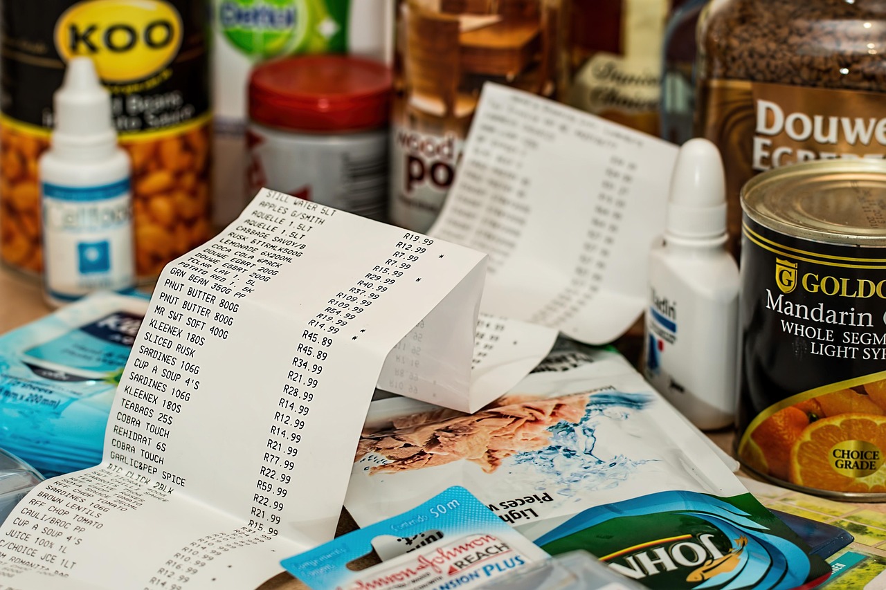 Persoon bij supermarktkas met boodschappenbon in de hand