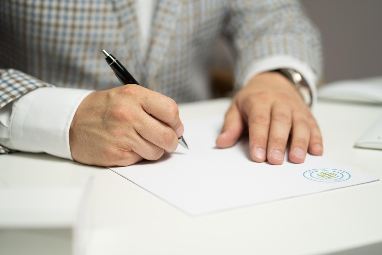 Twee mensen die samen een document ondertekenen aan een tafel