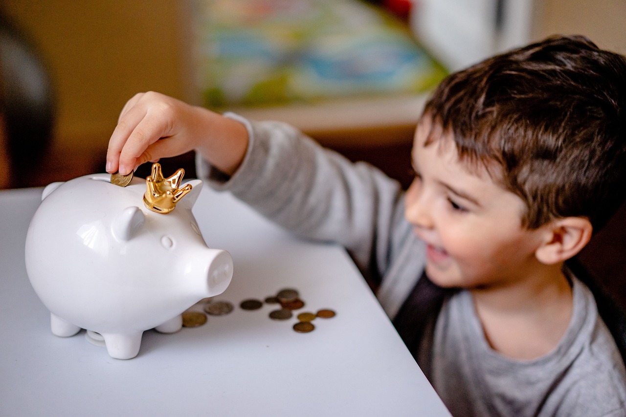Spaarpot van een kind naast een rekenmachine, symbool voor kindvermogen en belasting